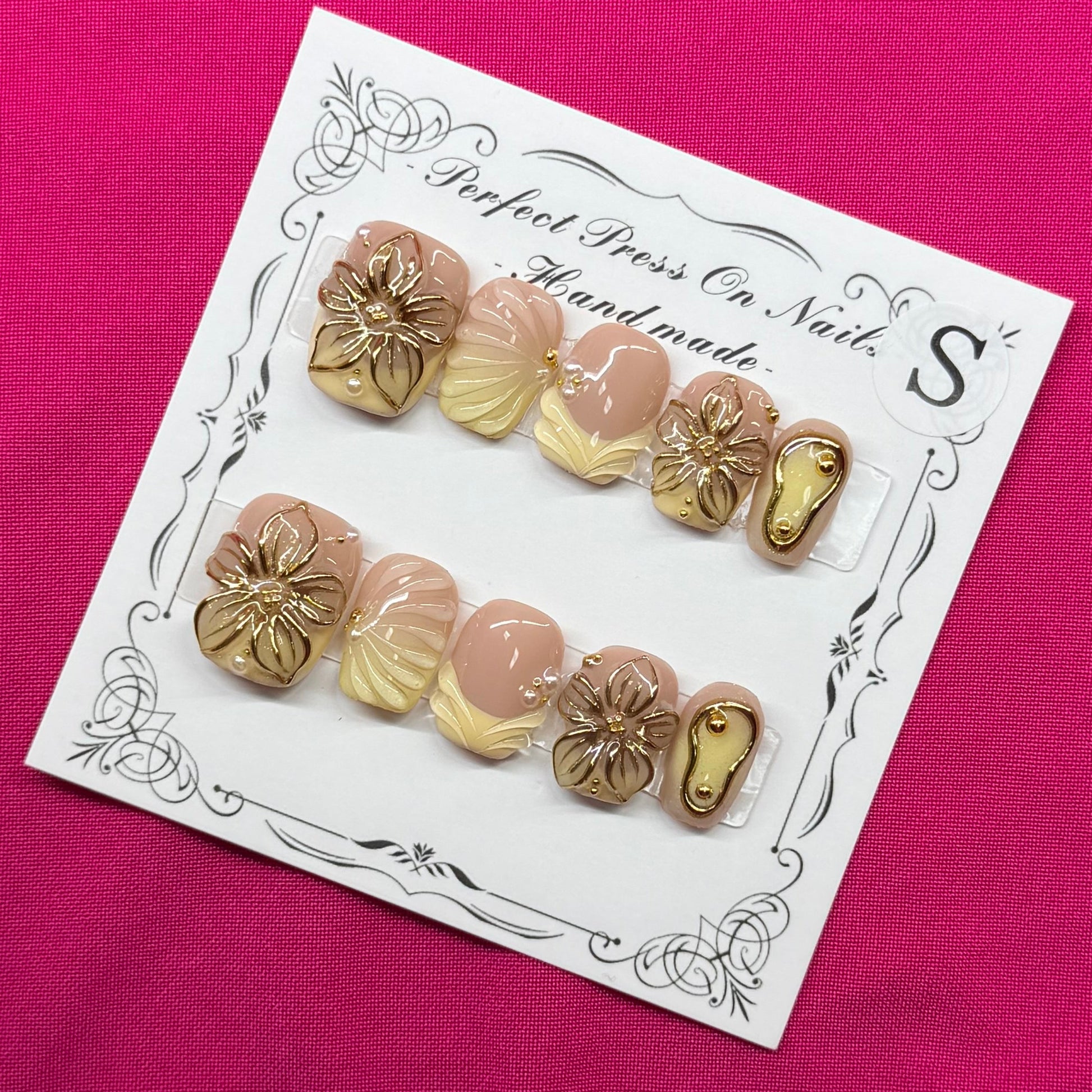 A pair of wooden bead nail art starter kits on a white display card, placed on a bright magenta fabric background.